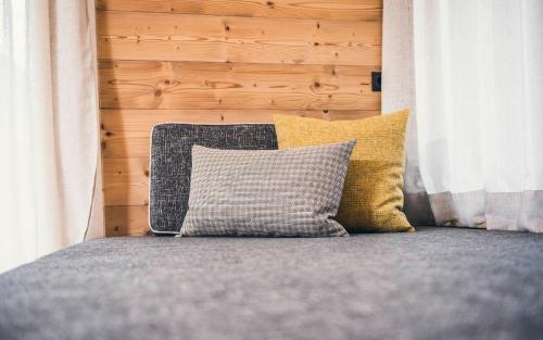 a bed with yellow and gray pillows in a bedroom at Lichtung Woldererhof Auszeit in Racines