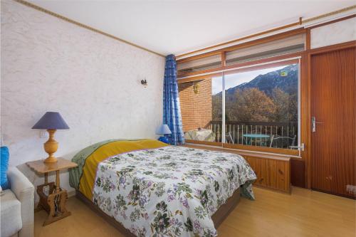 a bedroom with a bed and a large window at F1 Massif du Canigou in Vernet-les-Bains