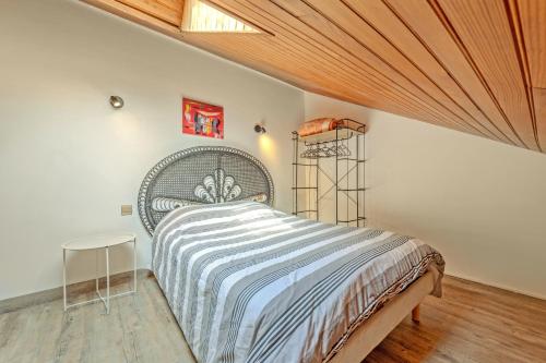 a bedroom with a bed and a wooden ceiling at La Gitounette proche Monts d'arrée in Poullaouen