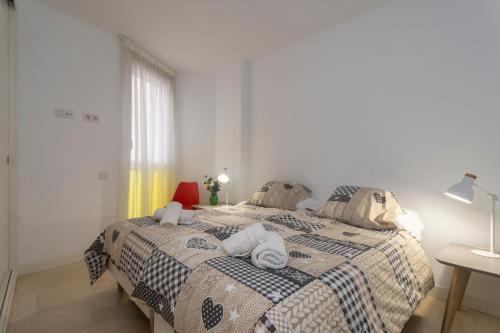 a bedroom with a bed with towels on it at Modern Apartment next the Beach in Marbella