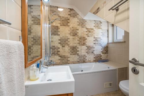 a bathroom with a sink and a bath tub at Beach Apt 1 In Burgau in Burgau