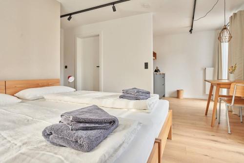 two beds in a white room with towels on them at Alte Seifensiederei - Viktor in Bad Tölz