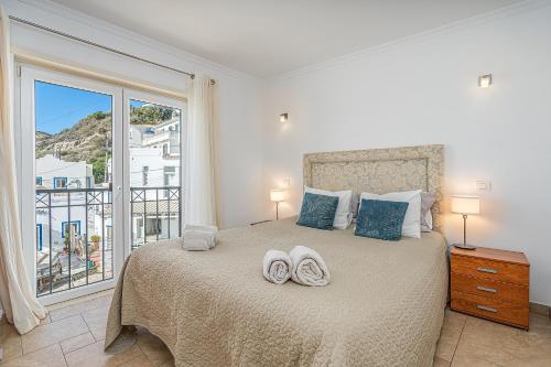 a bedroom with a bed with two towels on it at Beach Apt 1 In Burgau in Burgau