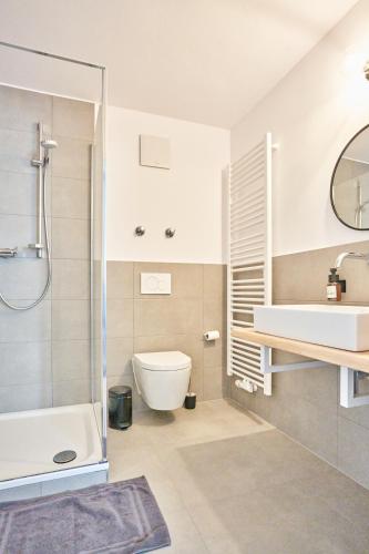 a bathroom with a tub and a toilet and a sink at Alte Seifensiederei - Viktor in Bad Tölz