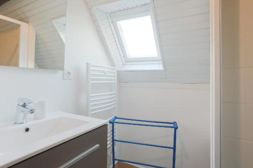 a bathroom with a sink and a window at Ker Ar Vro - Maison atypique in Locquirec