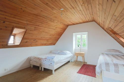 a bedroom with a bed and a wooden ceiling at Ker Ar Vro - Maison atypique in Locquirec