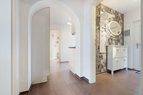 a hallway with a mirror and a tile floor at Connys Ferienwohnungen Sonne in Winsen