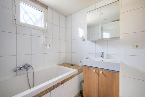 a white bathroom with a tub and a sink at Maison avec studio Cros de Cagnes in Cagnes-sur-Mer