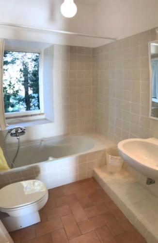 a bathroom with a tub and a toilet and a sink at La Casa Rossa 2 in Bibbona