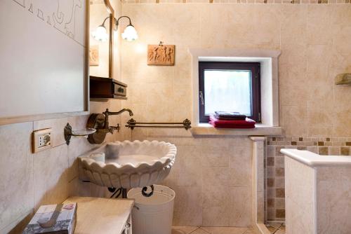 a bathroom with a sink and a toilet and a window at Baita Chalet Alabama in Arsiè