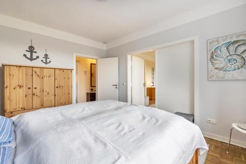 a white bedroom with a large white bed in it at Alte Schule Pahlkrug in Linden