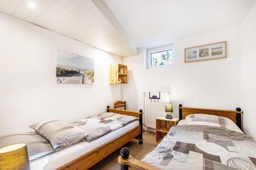 two beds in a bedroom with white walls at Ferienwohnung Hennings in Bargenstedt