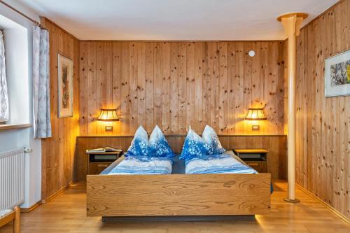 a bedroom with a bed with blue pillows on it at Stöcklhuberhof in Vandoies