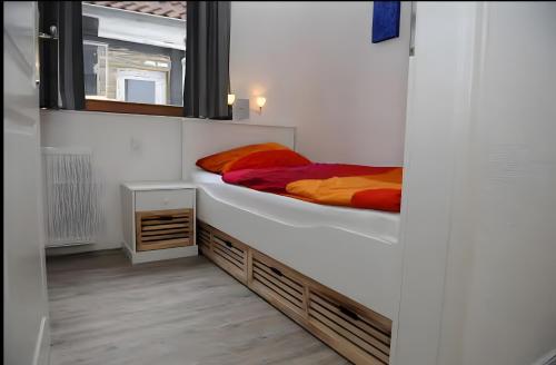 a bedroom with a bed with orange and red sheets at Ferienwohnungen Wiese - Nickel 1 in Arnis