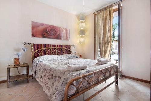 a bedroom with a bed and a large window at Colorful Apartment in Colico