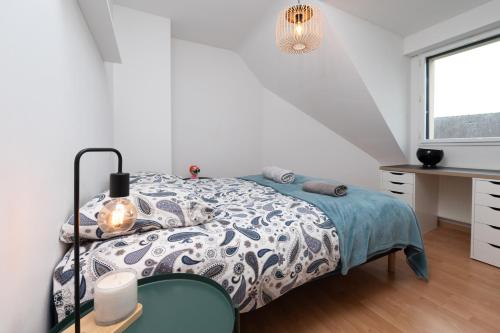 a bedroom with a bed and a desk and a window at Maison Ker Galeret in Sarzeau