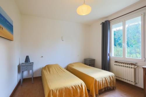 two twin beds in a room with a window at Maison Plouha proche plage in Plouha
