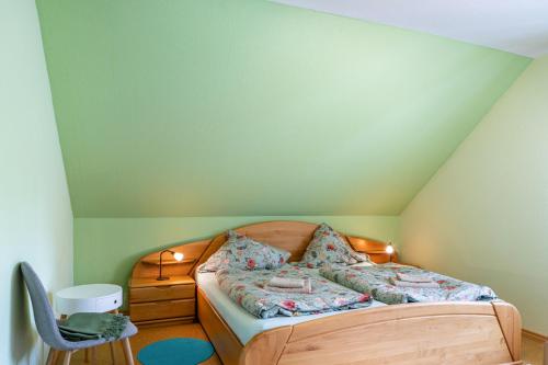 a bed in a room with a green wall at Sandhasen in Lauterbach