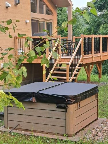 a trampoline sitting under a house with a deck at Kaïros - Private Spa & Golf Getaway in Saint-Basile