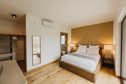 a bedroom with a bed and a table and a mirror at Luxe Villa Maxime in Lazise