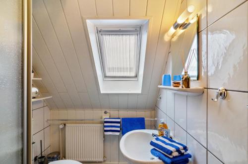 a small bathroom with a sink and a mirror at Ferienwohnung Karin in Marienhafe