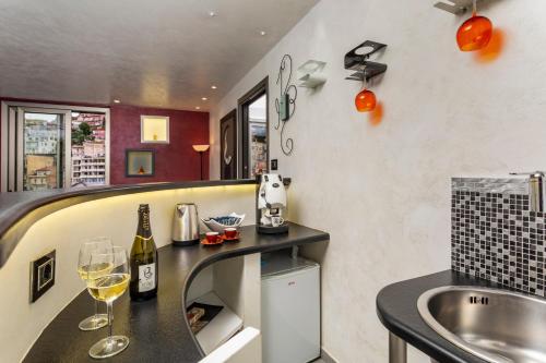 a kitchen with a counter with wine glasses and a sink at Tao Rama Suite in Taormina