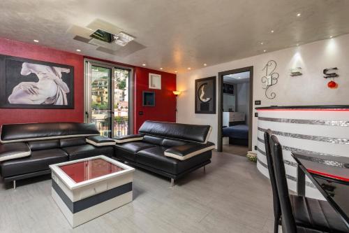 a living room with black leather furniture and red walls at Tao Rama Suite in Taormina
