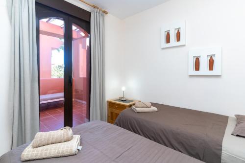 a bedroom with two beds and a door to a patio at Duplex apartment Estepona in Estepona