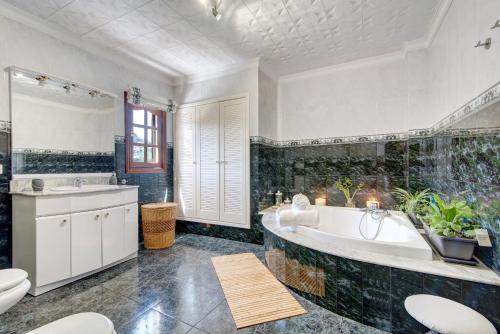 a bathroom with a tub and a toilet and a sink at Las Monarcas in Teror