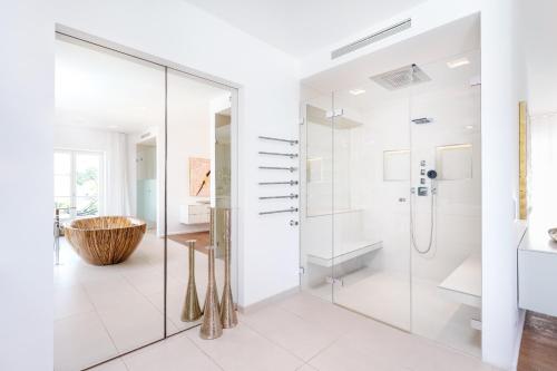 a bathroom with a glass shower and a wooden tub at Villa Oasis Del Mar in El Toro