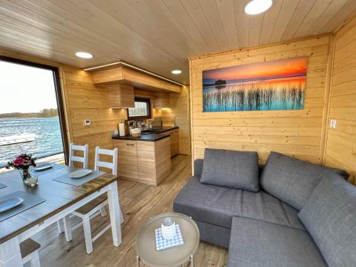 a living room with a couch and a table at Gemütliches Hausboot Seeliebe Woma in Fürstenberg