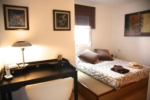 RadazulにあるApartamento el Canoのベッド、デスク(ランプ付)が備わる客室です。
