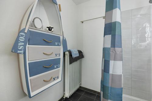 a bathroom with a surfboard next to a dresser at bleib. Boutique Premium Lake House in Allensbach