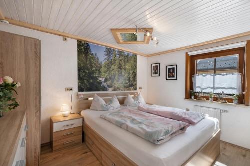 a bedroom with a large bed and a window at Ferienwohnung Steinbühlschlössle in Schönwald
