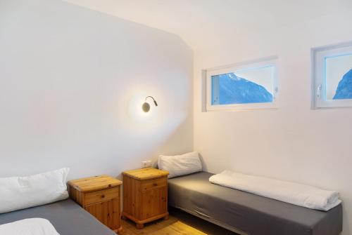 a room with two beds and two windows at Apartement Ben´s Auszeit Top 4 in Umhausen