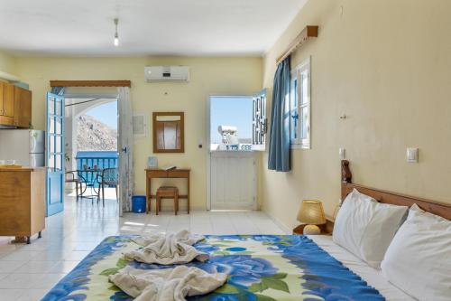 a bedroom with a bed and a kitchen with a view at Hotel Glaros Karpathos in Karpathos