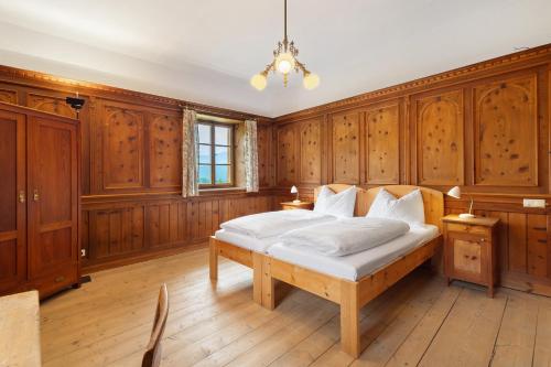 a bedroom with wood paneled walls and a bed at Ansitz Baumannhof Apt Erker Suite in Falzes