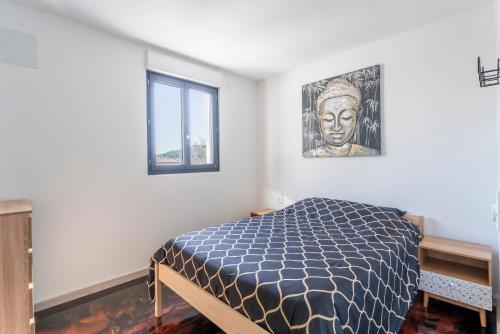 a bedroom with a bed with a picture of a statue at Villa Sérénity 10 pers maxi in Mondragon