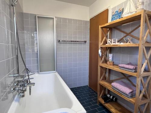 a bathroom with a white tub and blue tiles at Lichtdurchflutete Wohnung in Kempten