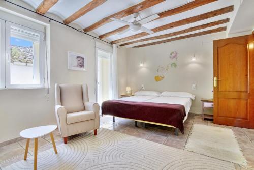 a bedroom with a bed and a chair at Casa Rural Prasat in Benirrama