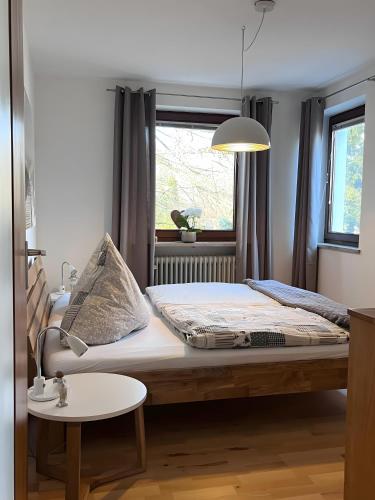 a bed in a room with a window and a table at Lichtdurchflutete Wohnung in Kempten