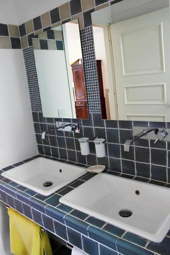 two sinks in a bathroom with two mirrors at Re Piano appartamento Le Colline in Modigliana