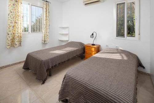 two beds sitting in a room with windows at Finca Carrion in Periana