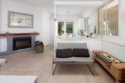 a living room with a chair and a fireplace at Finca Carrion in Periana