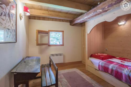 a bedroom with a bunk bed and a wooden table at Chalet Blanchon in Montricher-Albanne