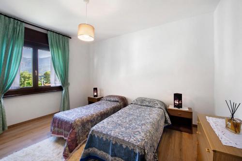 ein Schlafzimmer mit zwei Betten und einem Fenster in der Unterkunft Chez Sabrina in Champdepraz