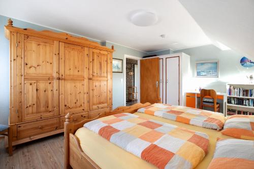 a bedroom with two beds and a wooden cabinet at Ferienwohnung Nordmeer in Kappeln