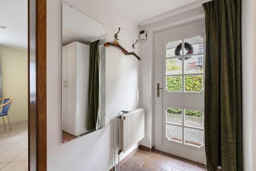 a hallway with a mirror and a window at Haus Gartenidylle in Wesselburen