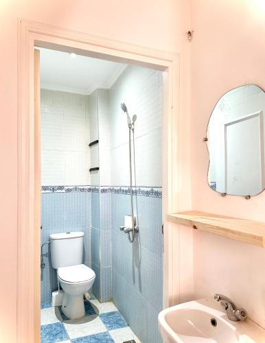 a bathroom with a toilet and a sink and a mirror at Tiri Hub in Tamraght Ouzdar