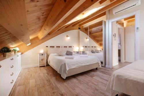 a large bedroom with two beds and wooden ceilings at Summer and Winter in Perledo